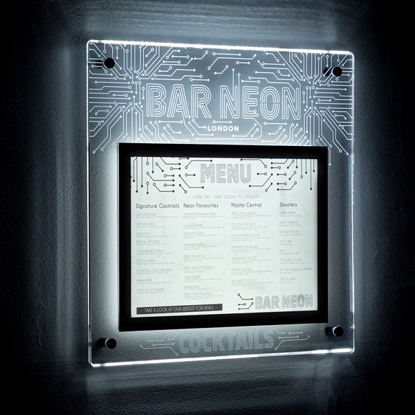 Edge lit acrylic menu case glowing on a dark wall, with an engraved cocktail bar logo