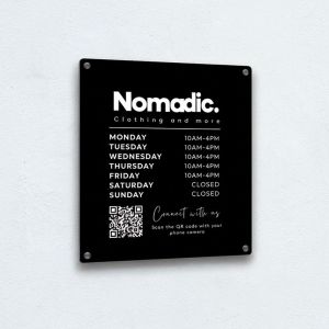 Black acrylic sign with customised design for a clothing company called Nomadic, includes a scannable QR code and opening times