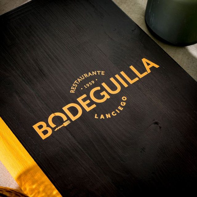 Black wooden menu cover with the Bodeguilla logo