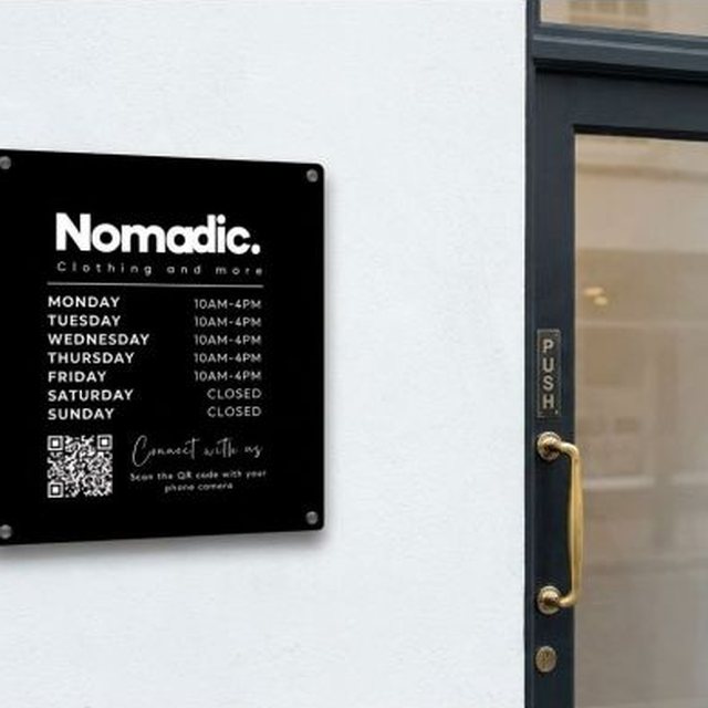 Black Nomadic wall sign with opening hours and QR code